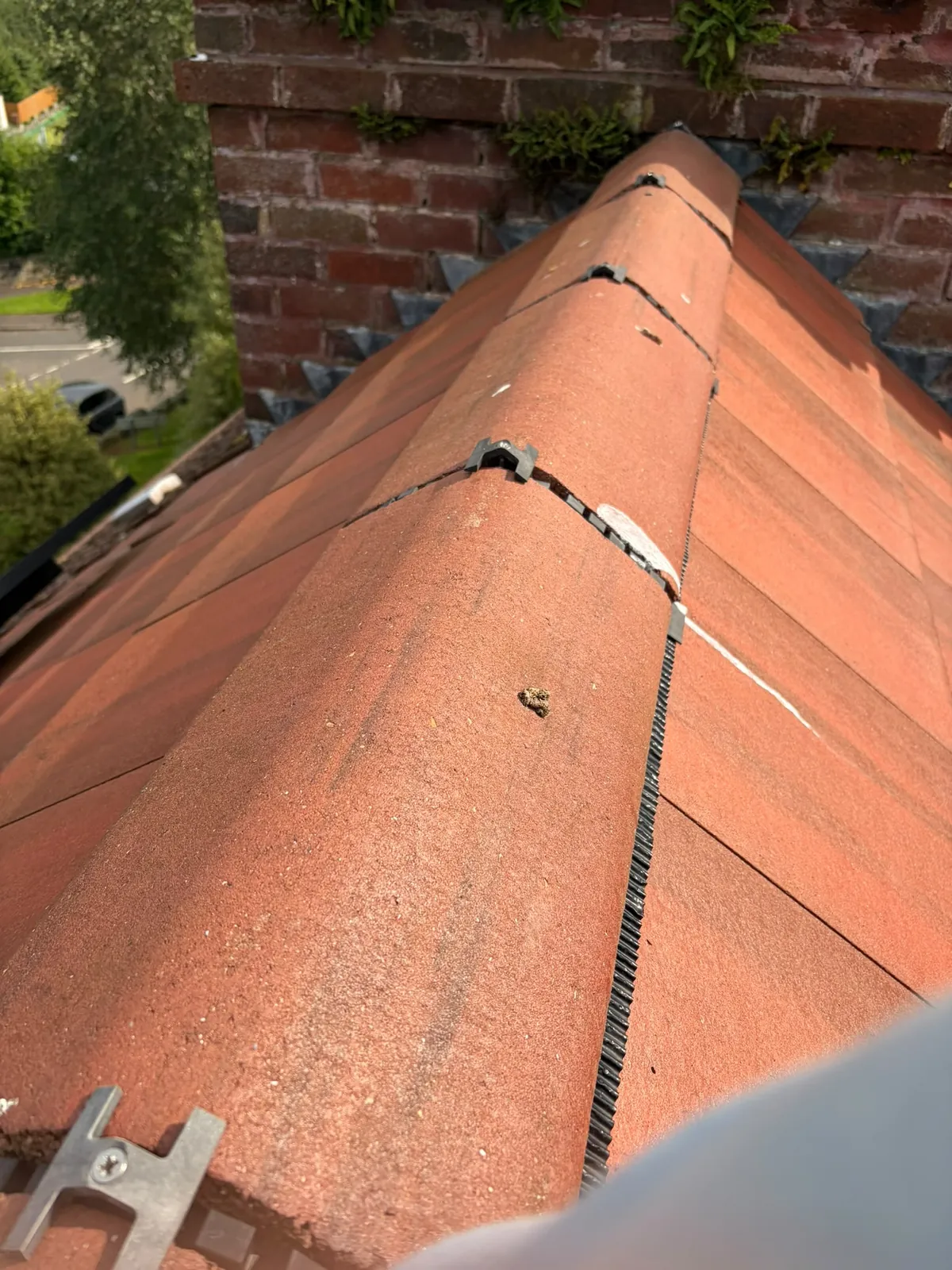 Dry fix ridge beside a chimney on a red tiled roof