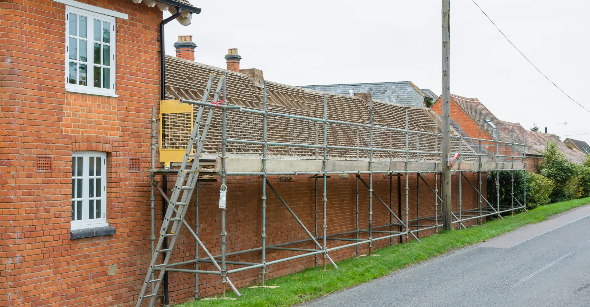 Scaffolding along a row of brick houses ready for roof work