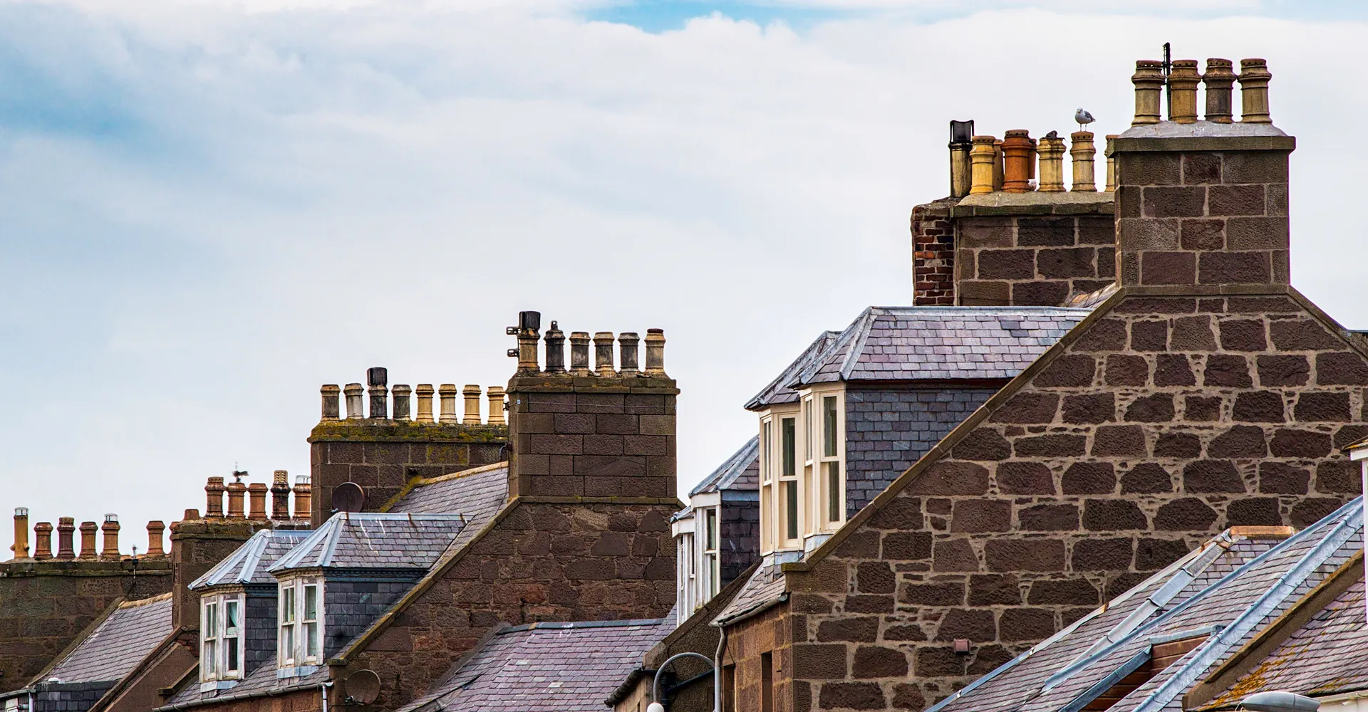 Sandstone terraced houses with slate roofs and tall chimney stacks